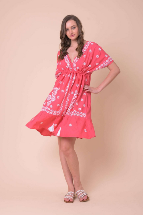 An image of a female model wearing the Handprint Dream Apparel Lively Dress in the colour Coral/White.