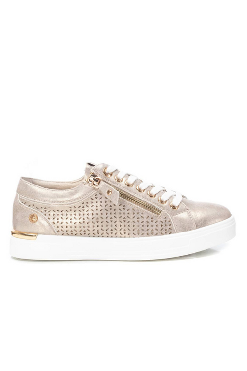 Xti Trainer. A gold women's trainer with lace fastening, zip detail on the side, and a die-cut side with geometric drawing