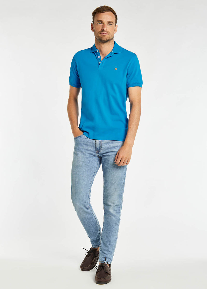 Dubarry Quinlan Polo Shirt. A short sleeve polo with collar, button fastenings, logo embroidery, and anti microbial/UPF 40 finish. Greek Blue.