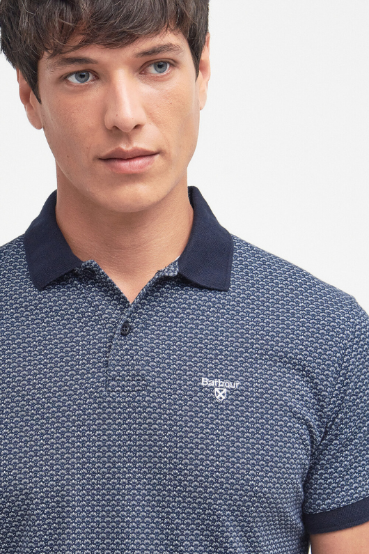 An image of a male model wearing the Barbour Shell Print Polo Shirt in the colour Classic Navy.