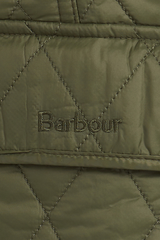 An image of a female model wearing the Barbour Otterburn Gilet in the colour Olive.