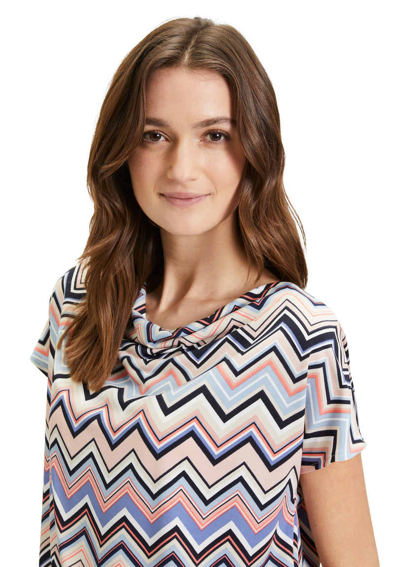 This Betty Barclay Printed Top has a figure-skimming design, dropped mid-length sleeves and a cowl neckline. It features a zig-zag pattern in multiple pastel colours including blue and pink. 