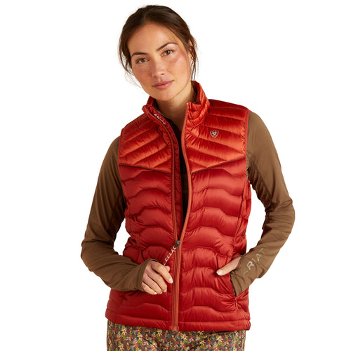 An image of a female model wearing the Ariat Ideal Down Gilet in the colour Iridescent Red.