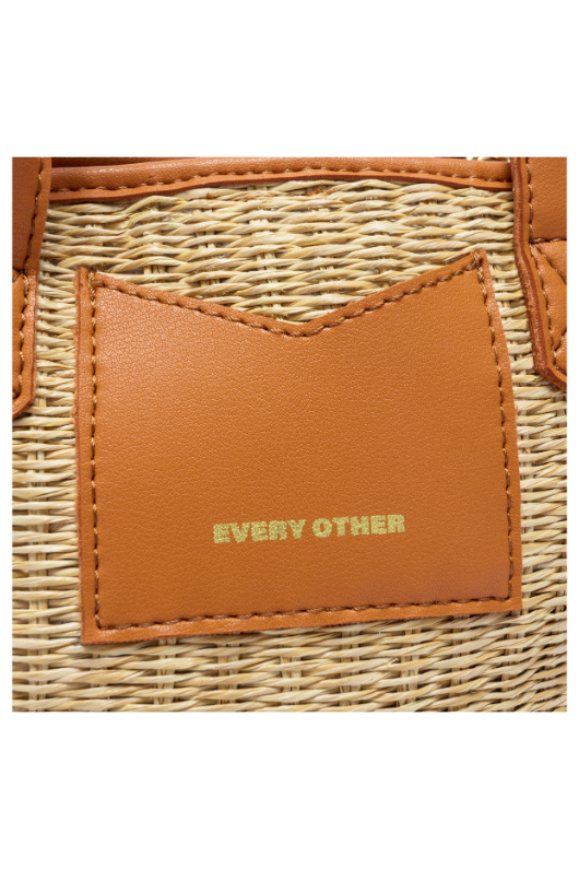 Every Other Straw Rattan Grab Bag. A small raffia bag with tan faux leather details, top handles, crossbody strap, and fully lined interior with zip pocket.