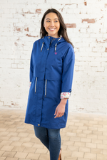 Lighthouse Pippa Coat. A waterproof women's jacket in indigo with an adjustable drawstring waist, a two-way front zip, a cosy cotton blend lining, and handy pockets.