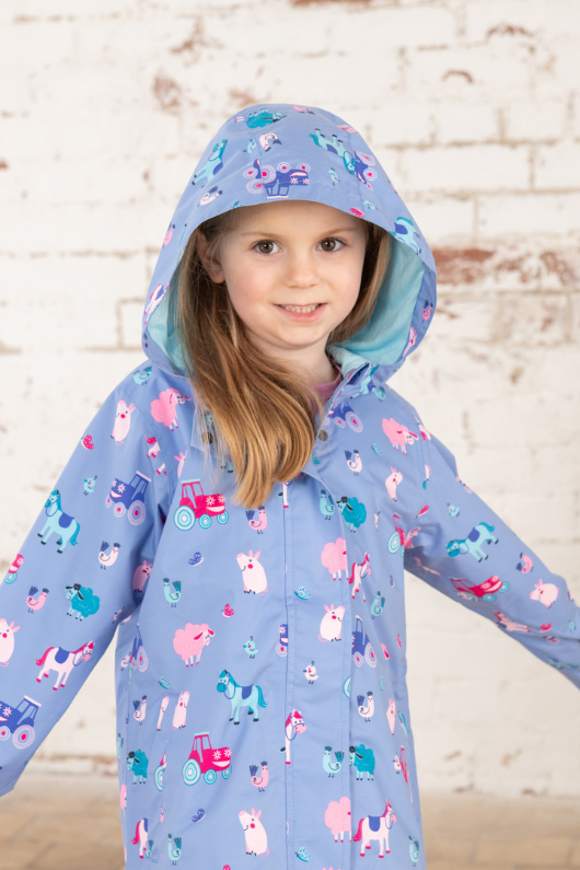 Lighthouse Olivia Jacket. A lightweight, waterproof kids coat with a soft jersey lining, two front pockets, a zip-up front, and a cute farm animal design on a lilac background.