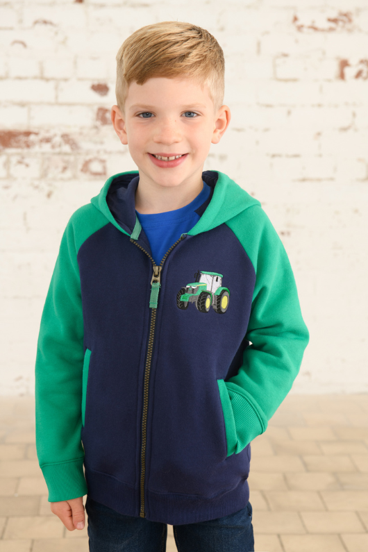 Lighthouse Jackson Full Zip Hoodie. A boys zip-up hoodie with waist pockets, a soft jersey lined hood, and a a navy torso with a tractor piqué on the chest and green sleeves.