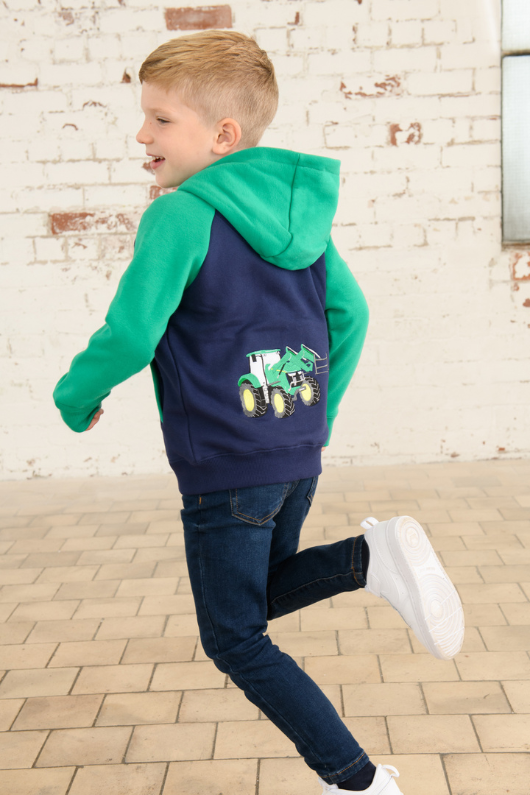 Lighthouse Jackson Full Zip Hoodie. A boys zip-up hoodie with waist pockets, a soft jersey lined hood, and a a navy torso with a tractor piqué on the chest and green sleeves.