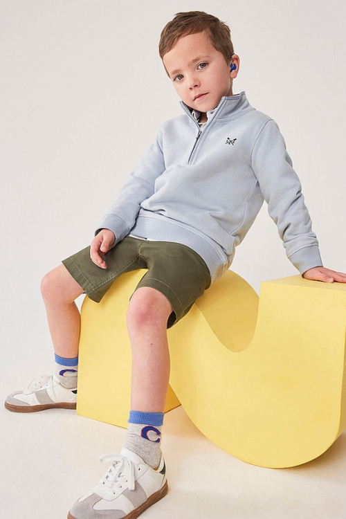 An image of a boy model wearing the Crew Clothing Mini Me 1/2 Zip Sweatshirt in the colour Light Blue.