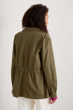 An image of a model wearing the Seasalt Far Horizon Organic Jacket in the colour Laurel.
