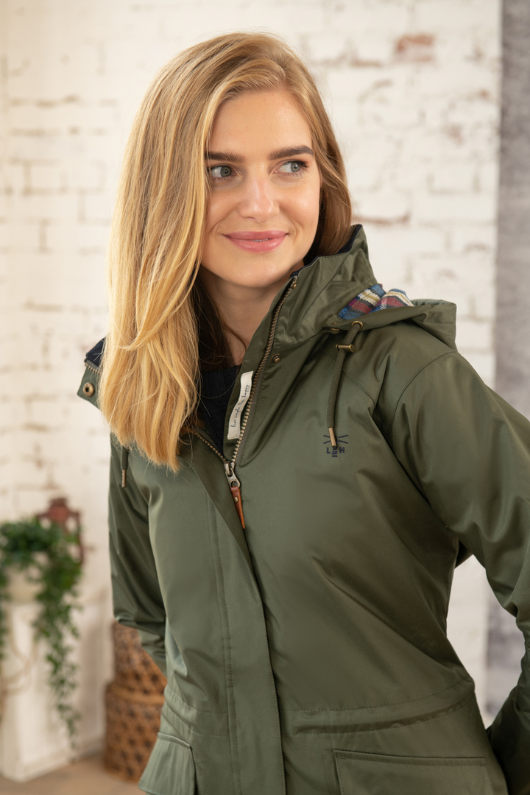 Lighthouse Kendal Raincoat. A fully lined, waterproof jacket with pockets, a two-way zip, a flattering hip length style, and a forest green colour design.