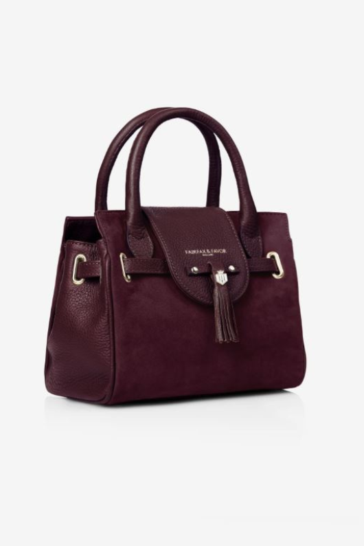 Fairfax & Favor The Mini Windsor. A mini windsor handbag with crossbody strap and tassel details. Suede and leather in the colour Plum.