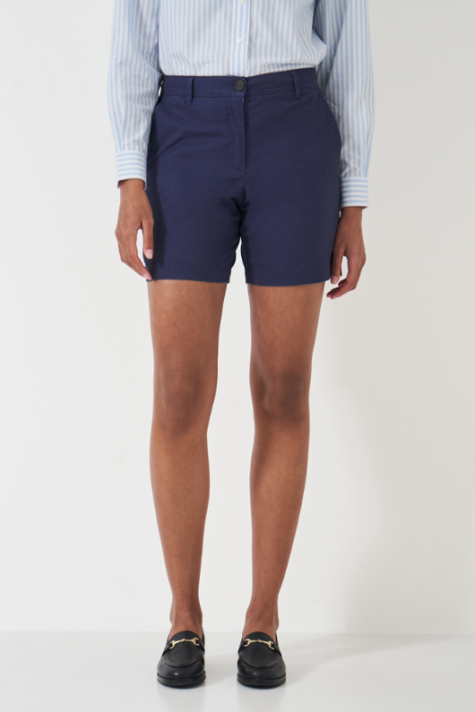 An image of a female model wearing the Crew Clothing Chino Shorts in the colour Navy.