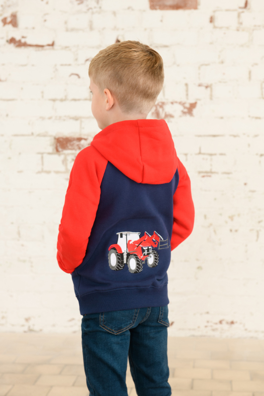 Lighthouse Jackson Full Zip Hoodie. A boys zip-up hoodie with waist pockets, a soft jersey lined hood, and a a navy torso with a tractor piqué on the chest and red sleeves.