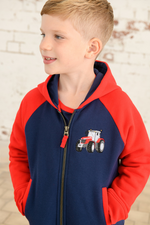 Lighthouse Jackson Full Zip Hoodie. A boys zip-up hoodie with waist pockets, a soft jersey lined hood, and a a navy torso with a tractor piqué on the chest and red sleeves.