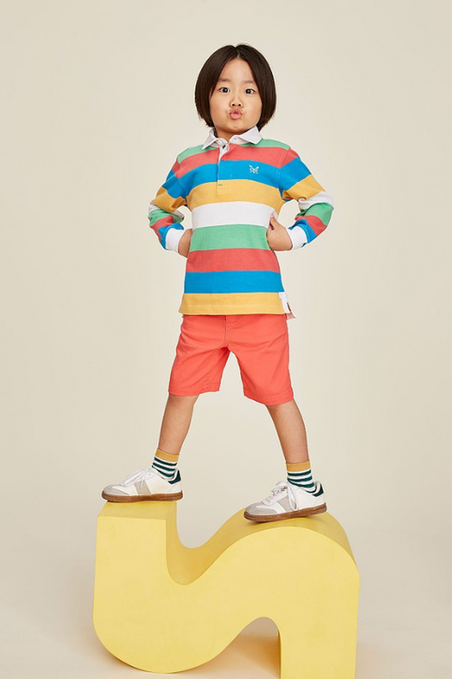 An image of a boy model wearing the Crew Clothing Long Sleeve Rugby Shirt in the colour Multi Yellow.