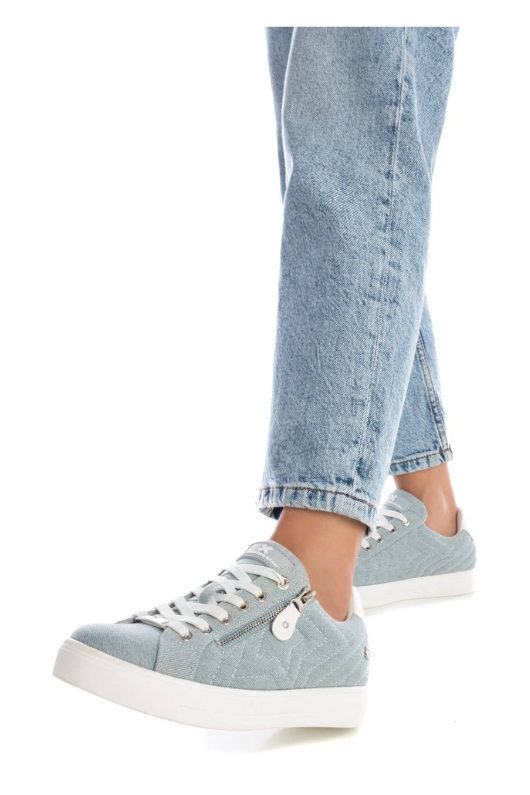 Xti Trainer. A women's trainer with star-shaped stitching on the side, zip closure with decorative laces, and a chic denim effect finish