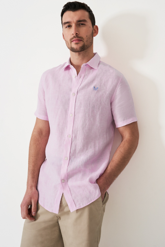 An image of a model wearing the Crew Clothing Short Sleeve Linen Shirt in the colour Heritage Pink White.