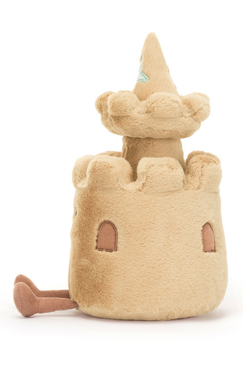 Jellycat Amuseable Sandcastle. A soft toy sandcastle with smiling face, sand coloured fur, and seashell details.