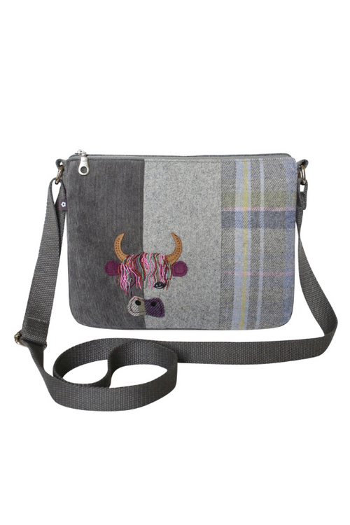 Earth Squared Applique Messenger Bag. A crossbody bag with zip closure and tweed design featuring a cow applique.