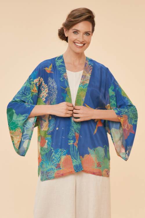 Powder Hummingbird Kimono Jacket. A lightweight jacket with a blue background and a bright colourful floral & hummingbird print