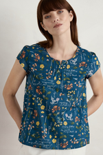 An image of a model wearing the Seasal Garden Gate Cotton Top in the colour Coastal Collection Light Squid.