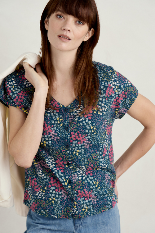 An image of a model wearing the Seasalt Studio Glass V-Neck Jersey Top in the colour Coastal Meadow Light Squid.