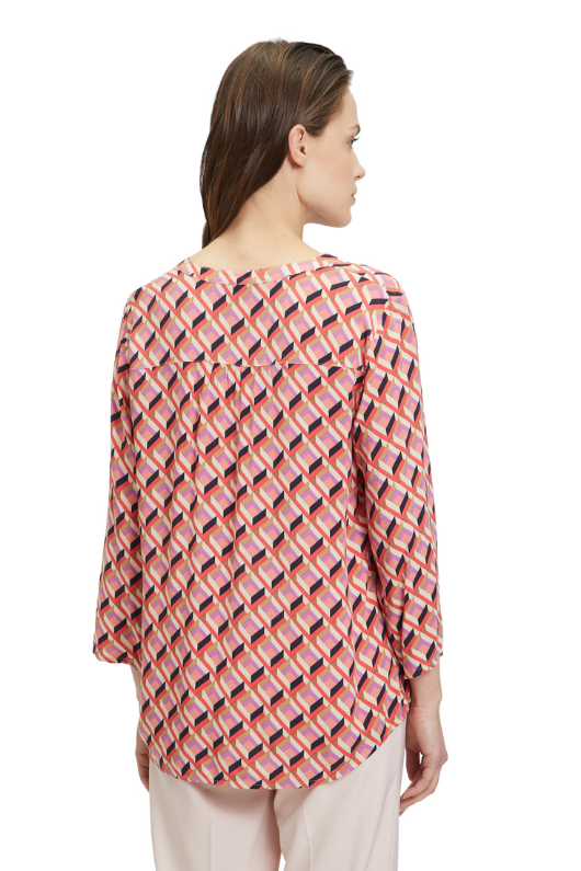 An image of a model wearing the Betty Barclay 3/4 Sleeve Pattern Blouse in the colour Red/Beige.