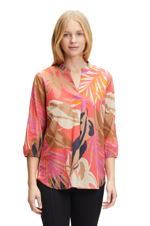 An image of a model wearing the Betty Barclay Leaf Print Tunic-Style Blouse in the colour Red/Beige.