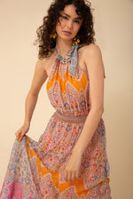 An image of a model wearing the Hale Bob Vera Halter Maxi Dress in the colour Orange.