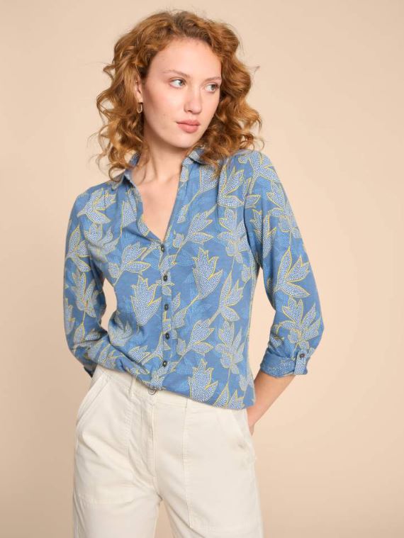 White Stuff Annie Printed Cotton Shirt. A slim-fit, women's shirt with a V-neck, button fastening and a leafy design on a blue background.