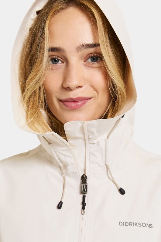 Didriksons Tilde Jacket 4. A lightweight, waterproof jacket with reflective prints on the chest and shoulders, hidden front pockets, a two-way adjustable hood, and adjustable cuffs
