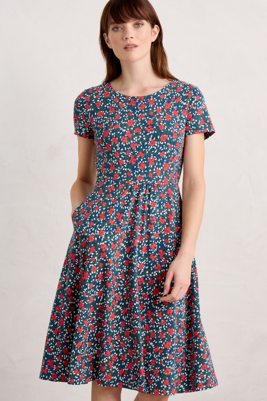 An image of a model wearing the Seasalt April Short Sleeve Dress in the colour Reed Flower Raincloud.