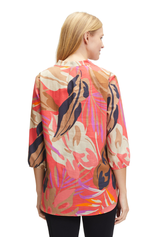 An image of a model wearing the Betty Barclay Leaf Print Tunic-Style Blouse in the colour Red/Beige.