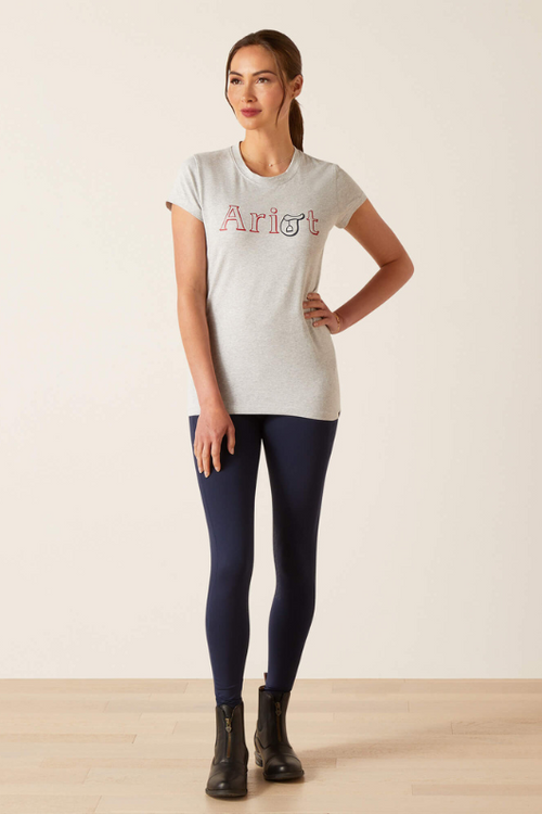 An image of a female model wearing the Ariat Saddle T-Shirt in the colour Heather Grey.