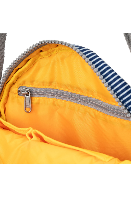 An image of the Roka London Paddington B Hickory Stripe Recycled Canvas Crossbody Bag.An image of the Roka London Paddington Bold Camo Recycled Canvas Crossbody Shoulder Bag.