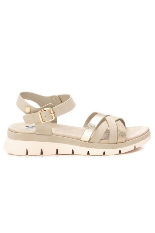 XTI Low Wedge Sandal. A pair of wedge sandals with intertwining metallic gold straps and gold buckle detail.