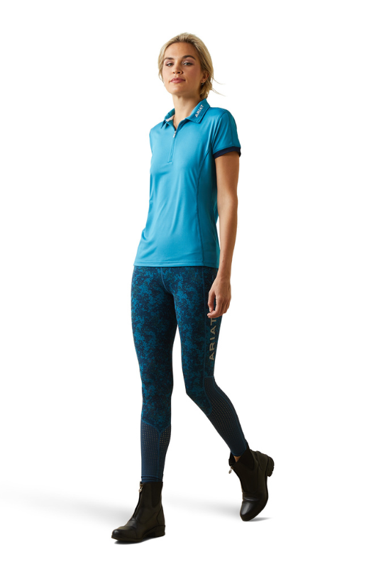An image of a female model wearing the Ariat Bandera 1/4 Zip Short Sleeved Polo Shirt in the colour Blue.