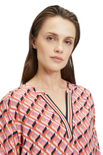 An image of a model wearing the Betty Barclay 3/4 Sleeve Pattern Blouse in the colour Red/Beige.