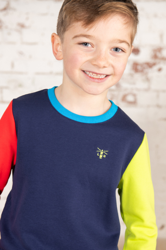 Lighthouse Finn Jersey. A boys sweatshirt with a crew neckline, a navy torso with one red sleeve and one lime sleeve