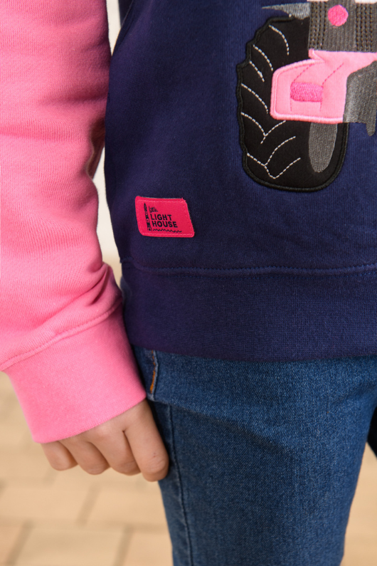Lighthouse Jill Hoodie. A girls hooded jumper with a kangaroo pocket, pink sleeves & hood, and a fun pink tractor design on the front.