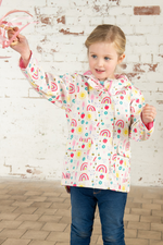 Lighthouse Heidi Jacket. A kids, waterproof coat with a soft jersey lining, and a sweet rainbows & sunshine design on a white background.