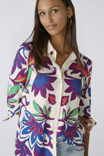 Oui Bold Floral Blouse. A casual cut blouse with long sleeves and collared neckline. This top has a silk touch quality, slightly longer length, and a multicoloured floral print.