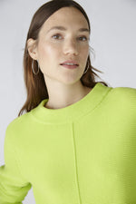 Oui Long Sleeve Turtle Neck Jumper. A casual cut, regular length jumper with long sleeves. This jumper has a stand-up collar and ribbed side insert and is a yellow-green shade.