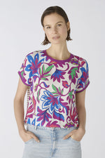 Oui Bottom Floral Blouse. An oversized cut, regular length top with short sleeves and round neckline. The neckline and armholes are a contrasting colour, whilst the front design is floral and the back is striped. This blouse is multicoloured and purple.