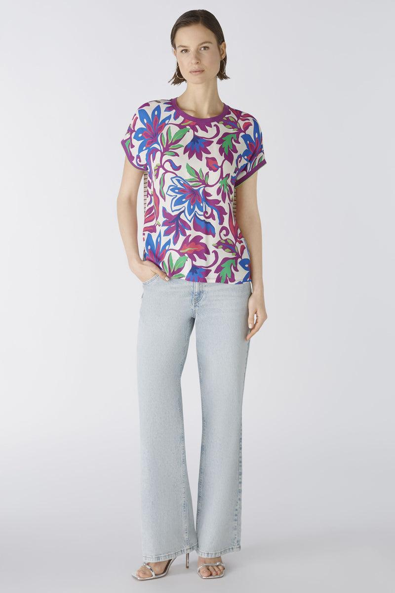 Oui Bottom Floral Blouse. An oversized cut, regular length top with short sleeves and round neckline. The neckline and armholes are a contrasting colour, whilst the front design is floral and the back is striped. This blouse is multicoloured and purple.