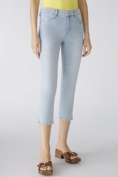 Oui Cropped Jeans. A pair of light blue denim jeans in a Capri style, with belt loops, five pockets, button and zip closure, and side slits.