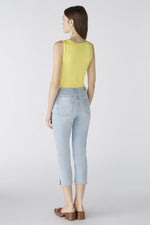 Oui Cropped Jeans. A pair of light blue denim jeans in a Capri style, with belt loops, five pockets, button and zip closure, and side slits.