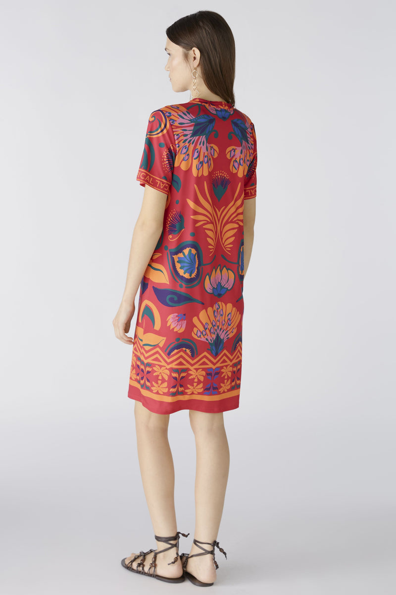 Oui Dress. An above-knee length dress with short sleeves, tunic neckline, and pink/orange all-over print.