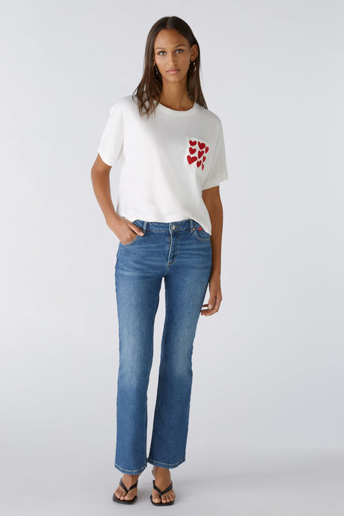 Oui Easy Kick Jeans. A regular fit, mid-waist jean with a flared fit. These jeans have a zip closure, belt loops, pockets and a heart embroidery. They are a classic mid-blue wash colour.